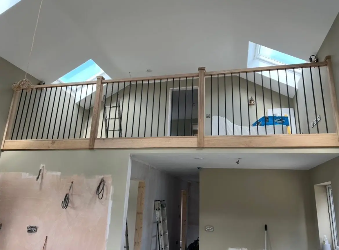 Oak handrail with black steel spindles along a mezzanine landing