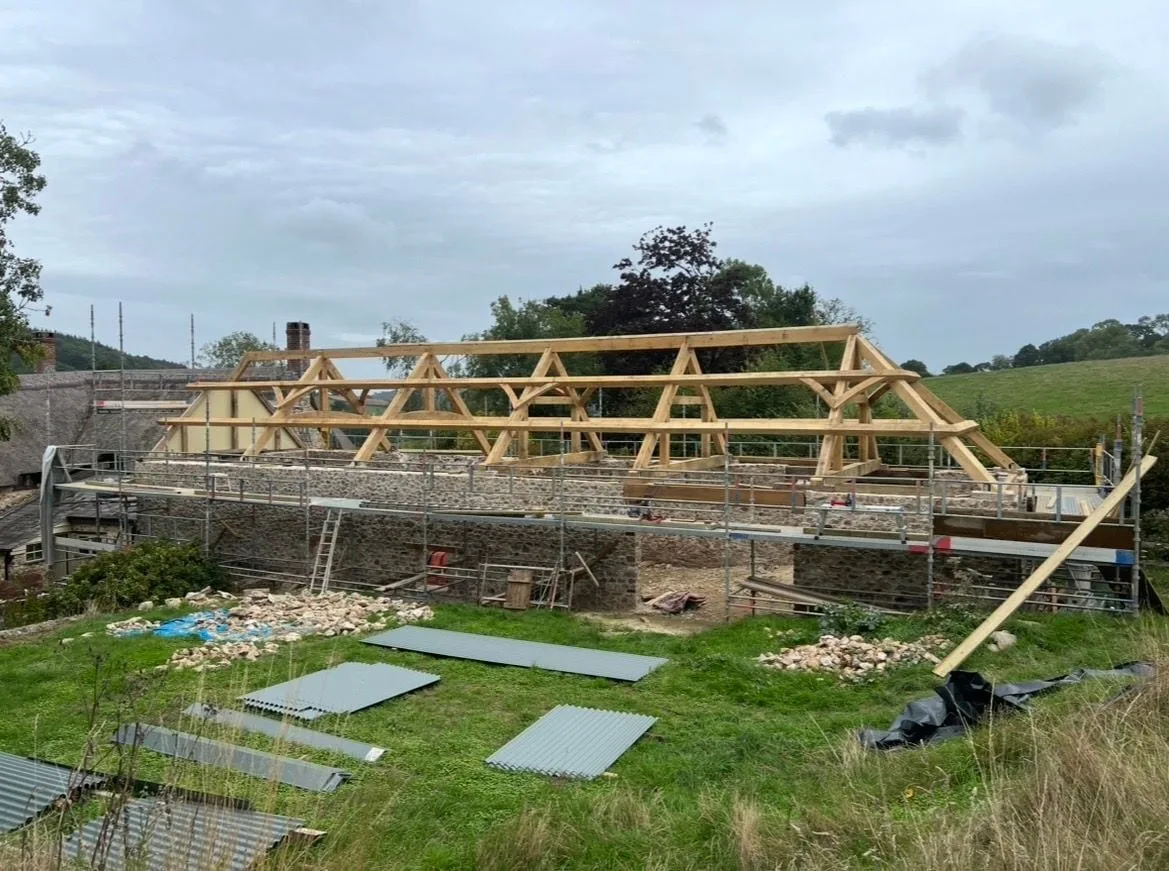 Oak roof frame standing on the stone walls of a building, before the roof covering goes on