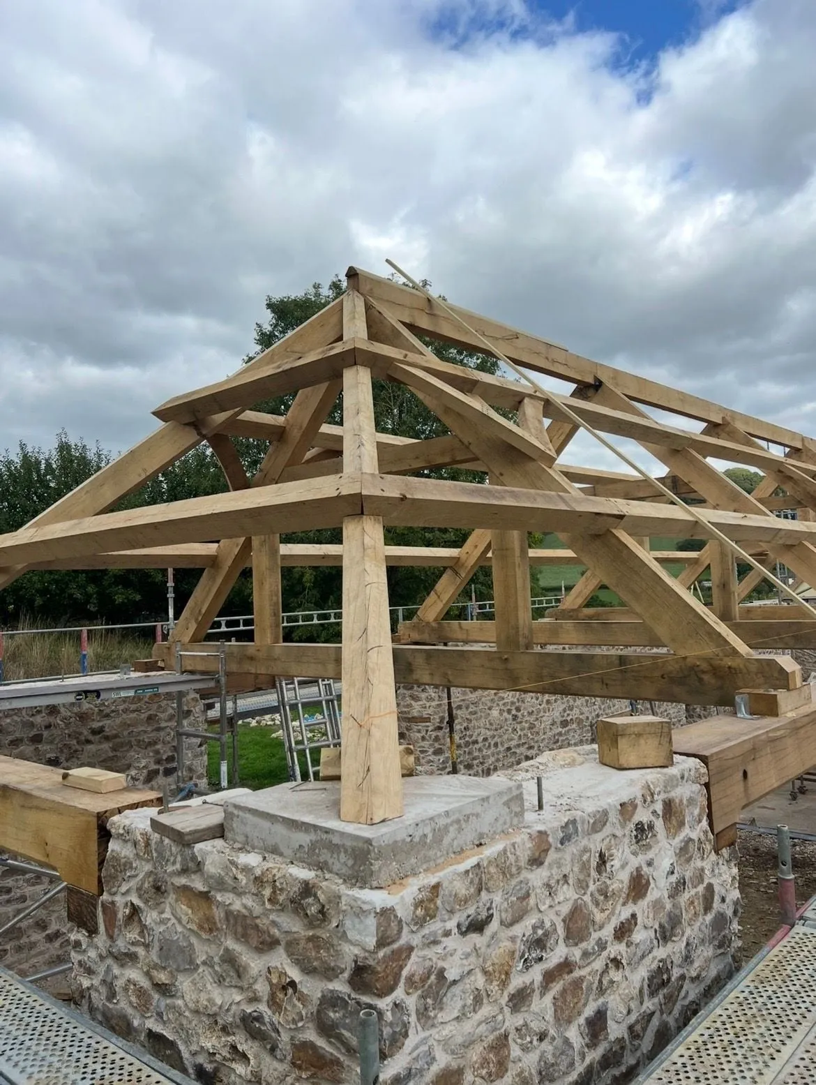 Oak roof frame and trusses raised on the stone walls of a building