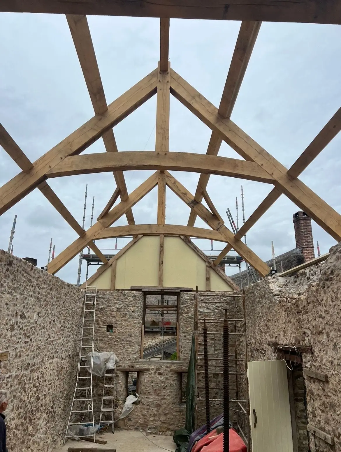 Oak roof trusses with curved braces, open to the sky