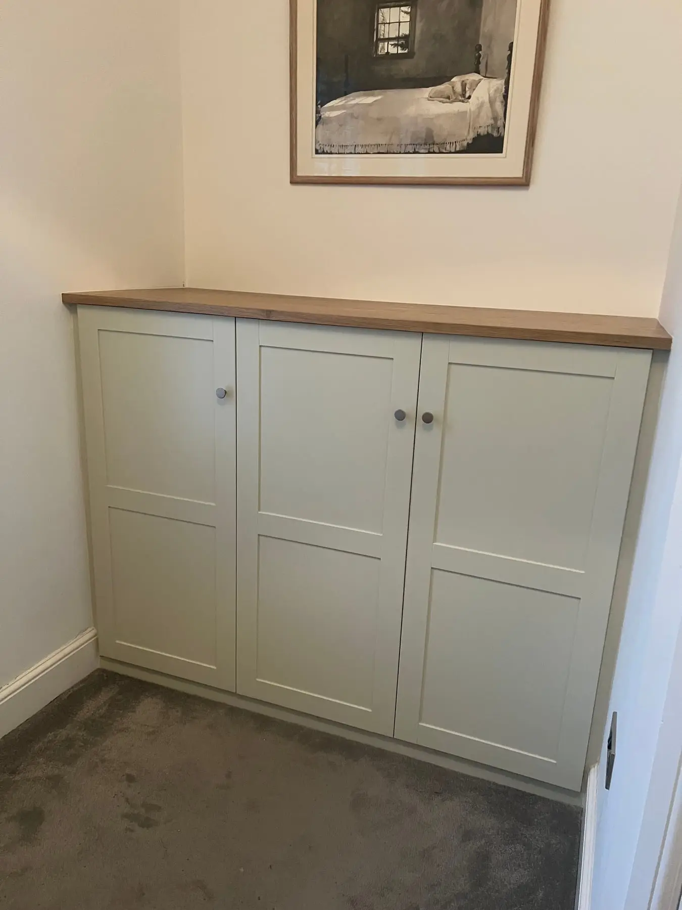 Alcove cupboards painted sage green with an oak worktop